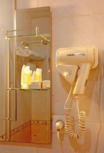 a hair dryer in a bathroom with a mirror at Nobleza Hotel in Kigali