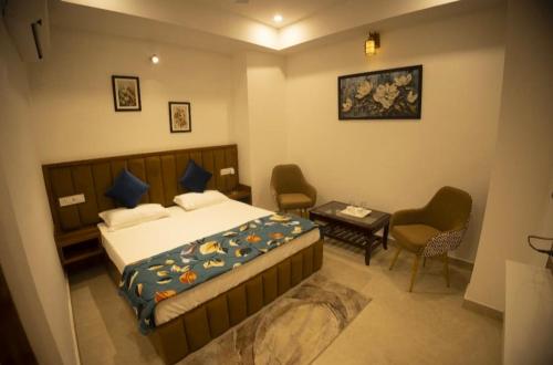 KurukshetraにあるHotel Rajshreeのベッドとテーブルと椅子のある寝室
