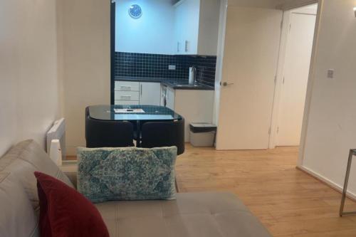 een woonkamer met een bank en een tafel bij London 1 Bed Apartment close to Barking Station in Barking