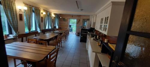 a restaurant with wooden tables and chairs and windows at Gościniec, kwatery prywatne przy stoku w Zieleńcu in Duszniki Zdrój