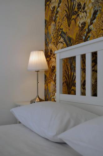 a white bed with a lamp next to a wall at Casa D'Amuri in Belpasso