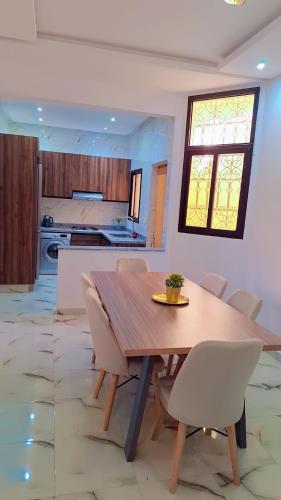 マラケシュにあるAppartement Aéroport Center Marrakechの木製のテーブルと椅子のあるキッチンとダイニングルーム