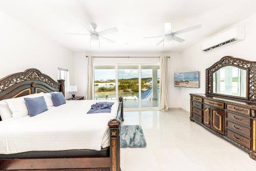 プロビデンシャレスにあるNew Unique Villa Blue Top! 2 Bedroom Waterfrontのベッドと鏡付きのドレッサーのある寝室