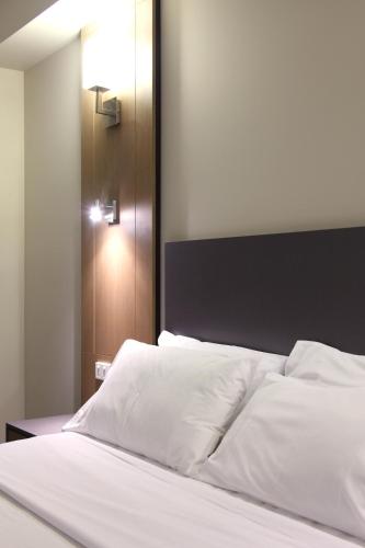 a bed with white sheets and a black headboard at Brisbane International Virginia in Brisbane
