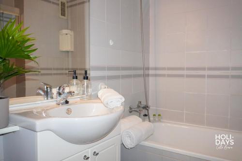 a white bathroom with a sink and a tub at Holidays Rincón Vista Mar PL4 in Empuriabrava