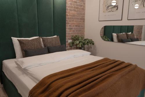 a bed with a blanket on it with a mirror at Harbor Apartments - Aparthotel przy Rynku in Katowice