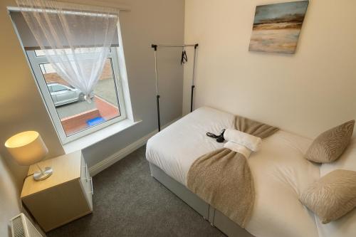 a small bedroom with a bed and a window at Near the Beach 3Bedroom Apartment WIFI Modern & Spacious Sleeps 6 in Hawthorn