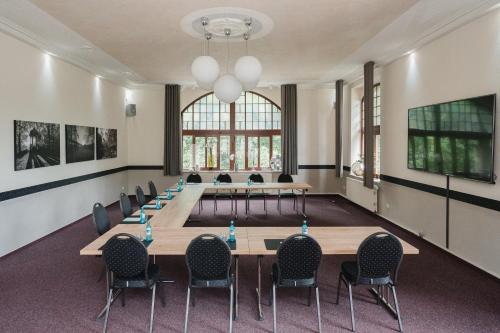una sala conferenze con un lungo tavolo e sedie di Parkschlösschen Lichtenstein Sachsen a Lichtenstein