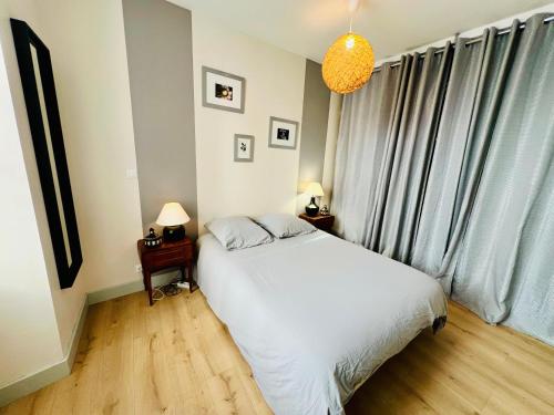 a bedroom with a white bed and a window at Le Maréchal - Coeur de ville in La Rochelle