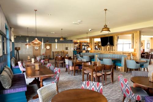 a restaurant with tables and chairs and a bar at Cosy Little Home By The Sea in West Mersea