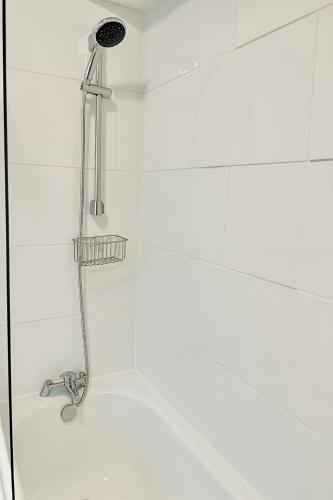 a shower with a shower head in a bathroom at 3-BR Beachside Escape -Perfect for Families & Groups -Spacious & Cozy in Hawthorn