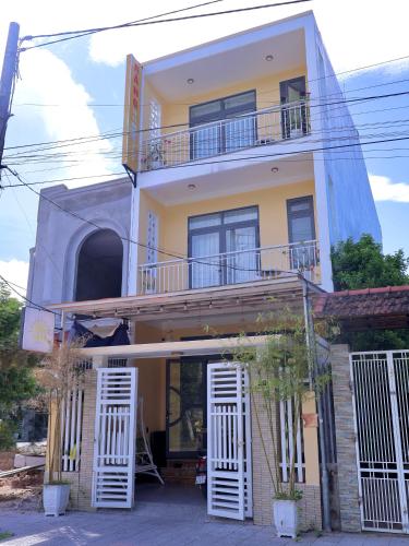 a yellow house with white doors and windows at Nắng Homestay Huế in Hue