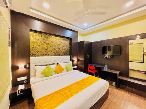 a bedroom with a bed and a desk and a television at Hotel Grand Bhagwat Udaipur Inn City Centre in Udaipur