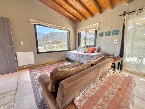 a living room with a couch and a bed at Wabi sabi, casita de montaña con pileta in Mendoza