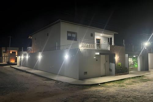 a white house at night with lights on it at Eficiência - Casa Recanto dos Ventos in Camocim