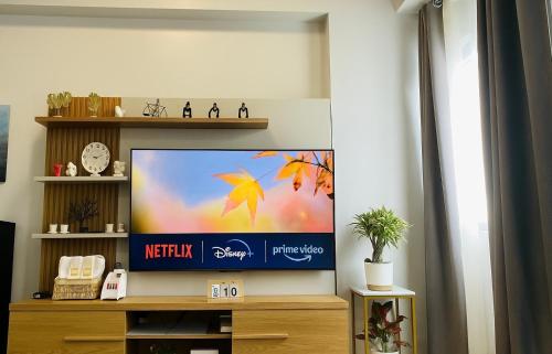 a flat screen tv sitting on a wooden entertainment center at Condo Stay Near SM City Santa Rosa Mall in Ibaba