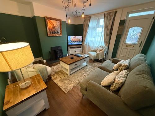 a living room with a couch and a tv at Laura Ashley cosy inner terrace in Barnsley