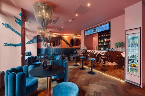 un restaurant avec des chaises bleues et un bar dans l'établissement VISIONAPARTMENTS Lugano - contactless check-in, à Lugano