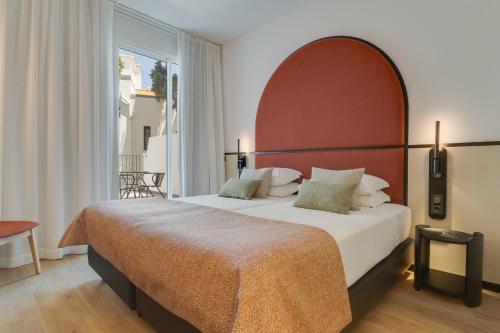 a bedroom with a large bed with a large window at Hotel do Carmo in Funchal