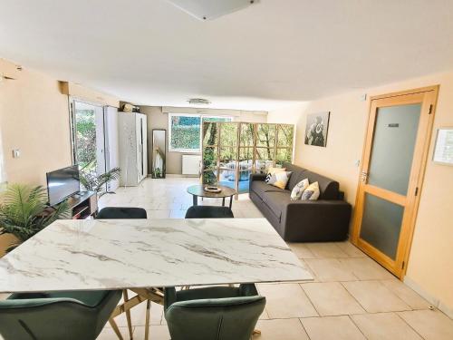 ein Wohnzimmer mit Tisch und Couch in der Unterkunft Le Rocher de Bel Air -40m2 -Chaleureux 3 étoiles in Saint-Aignan-Grand-Lieu