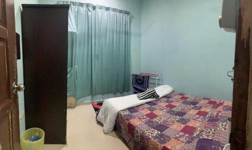 a bedroom with a bed with a quilt on it at Reisya Homestay in Kepala Batas