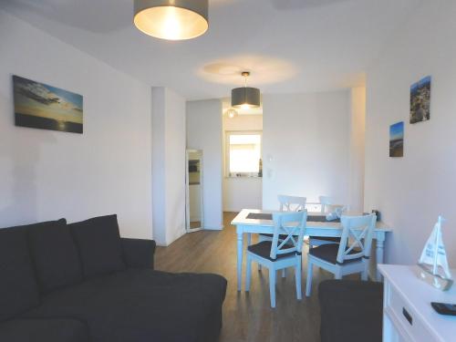 a living room with a couch and a table and chairs at FeWo "Hafenquartier" in Barth