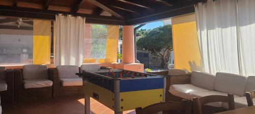 una mesa de ping pong en una habitación con sillas en Caserta Holiday Rent, en Ustica