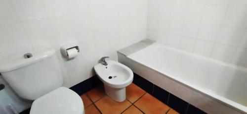 a white bathroom with a toilet and a sink at La Casa Maria in Pego