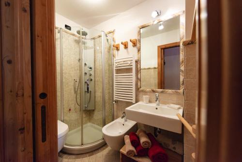 a bathroom with a sink and a toilet and a shower at Chalet Pian in Campitello di Fassa