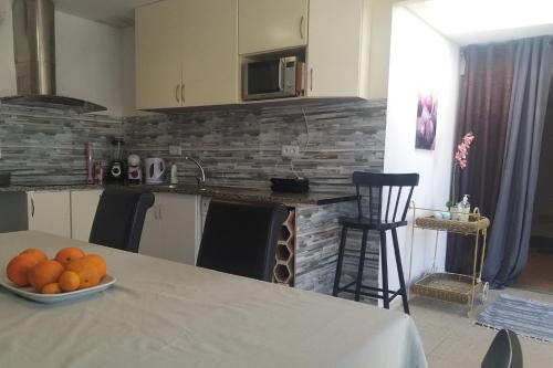 a kitchen with a table with a bowl of oranges on it at 2-Bed House - Garden Parking Pets in Viana do Castelo