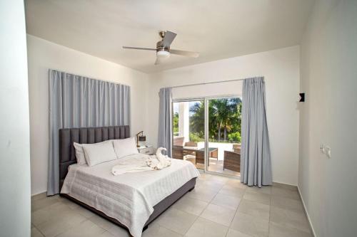 Sosuaにある3bedrooms villa at Villas Tisuのベッドと大きな窓のある寝室