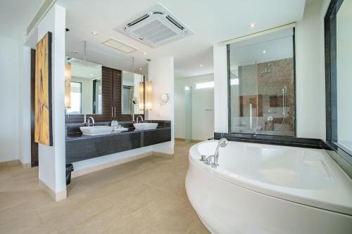 a large bathroom with two sinks and a tub at Raya Villa, 2 Bed Beachfront Villa Private Pool in Ban Saiyuan (1)