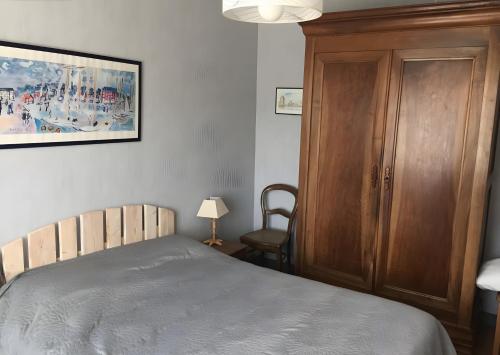 a bedroom with a bed and a wooden cabinet at Maison de village in Île dʼAix
