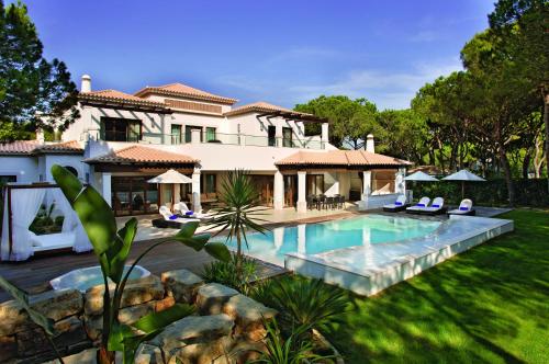 ein Haus mit Swimmingpool im Garten in der Unterkunft Pine Cliffs Village in Albufeira