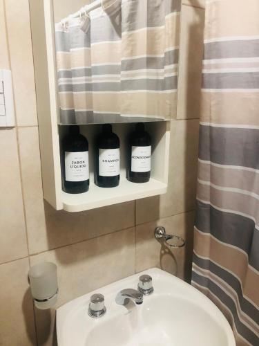 a bathroom with a sink and a shower curtain at Cabañas El bosque DLM in Uspallata