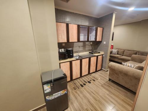 a kitchen and living room with a refrigerator and a couch at شقق مفروشة الهتون تاور شارع الحج in Miná