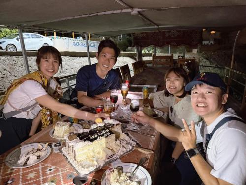 a group of people sitting around a table with food at Amon guest house in Abu Simbel