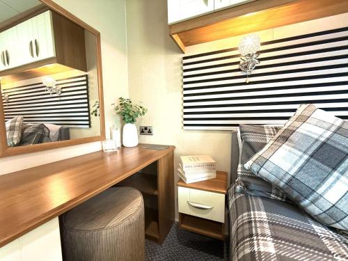 a bedroom with a desk and a bed and a mirror at Seashell Retreat in Scarborough