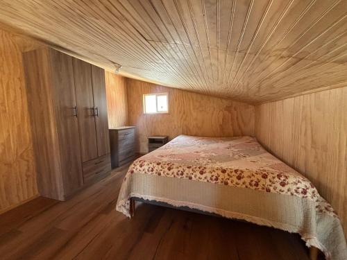 Un dormitorio con una cama con techo de madera. en Tiny House in Valdivia, en Valdivia