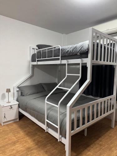 a bedroom with two bunk beds with a ladder at Pakkan Hotel พักกาญจน์ in Kanchanaburi City