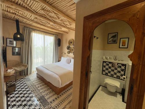 a bedroom with a bed and a bathroom with a toilet at Palm Surf & Spa Hotel Agadir in Agadir