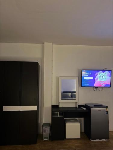 a room with a desk with a microwave and a tv at Pakkan Hotel พักกาญจน์ in Kanchanaburi City