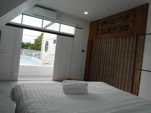 sypialnia z łóżkiem z oknem i basenem w obiekcie Windy Pool Villa Pattaya 3 King size bedrooms w mieście Bang Lamung