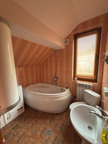 Un baño con una bañera grande y un lavabo. en Карпатський Дивокрай, en Perekrestnoye