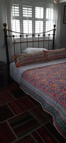 two beds sitting in a bedroom with a bedskirts at Quirky house in winchester in Winchester