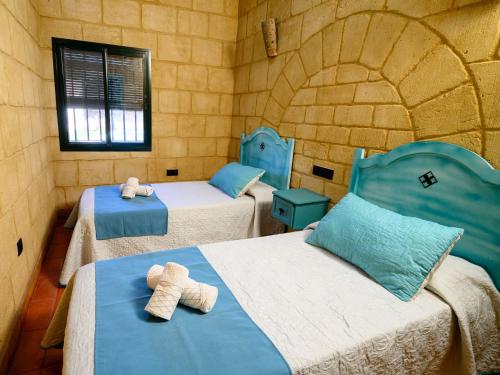 two beds in a room with two teddy bears on them at casacarmo in Carmona