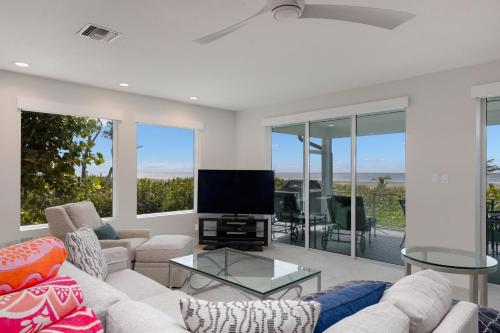 a living room with a couch and a tv at A Saba Wind North- Oceanfront Estate with Pool on Captiva Island in Captiva