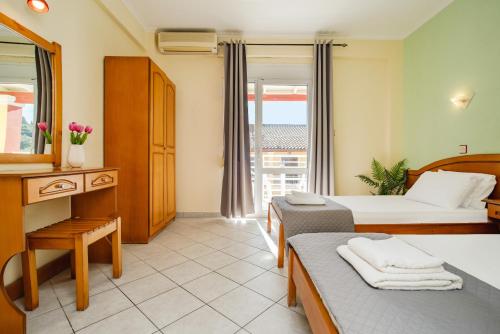 a hotel room with two beds and a window at Solena Studios Kavos in Kavos