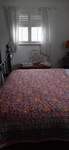 a large bed in a bedroom with a window at Quirky house in winchester in Winchester