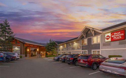 a hotel with cars parked in a parking lot at Best Western Plus Country Meadows Inn in Aldergrove